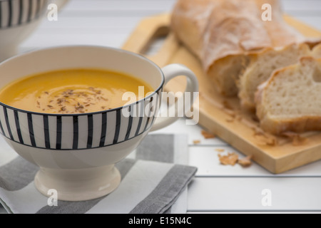 Retro-Stil Becher voll von Kürbissuppe mit geröstetem Kreuzkümmelsamen an der Spitze Stockfoto