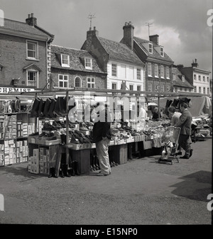 1950er Jahren Geschichtsbild der Käufer durchsuchen einen Marktstand, Verkauf von Warkton Schuhen auf dem Platz am Flughafen Newark on Trent, England. Stockfoto