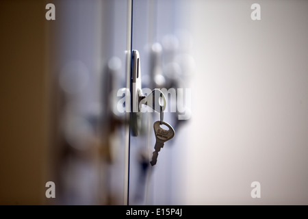 Ein Schlüssel in ein Schloss auf ein Schließfach im Büro Gymnasium Hallenbad Umkleide Raum Dressing. Stockfoto