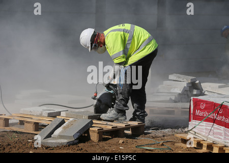 Handwerker-Arbeiter auf einer Baustelle disc Kreissäge schneiden Platten Kerb Abschnitte zu ebnen Stockfoto