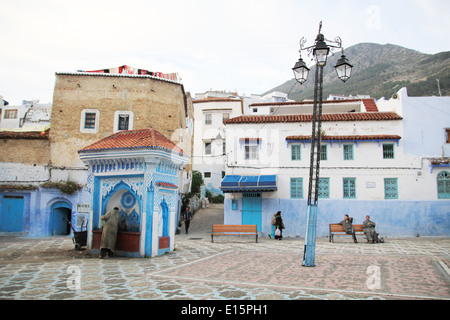 Mann trinkt aus einem Wasserbrunnen in Chefchaouen, Marokko Stockfoto