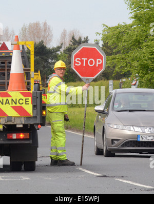 Bauarbeiter mit Lollipop Stop - Go Zeichen zur Steuerung von Datenverkehr auf Baustellen Vereinigtes Königreich Stockfoto