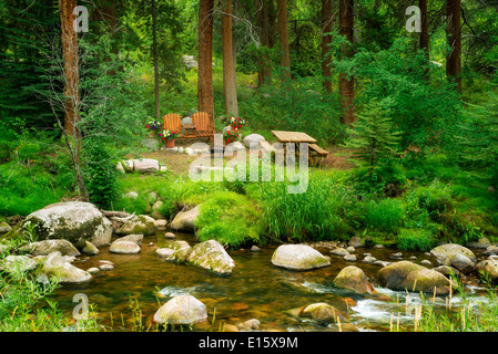 Picknickplatz mit Tisch Stühlen und Blumen auf Gore Creek. Vail, Colorado Stockfoto