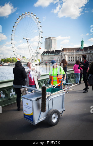 Straße-Reiniger mit Cart unter Touristen mit London Eye. Stockfoto