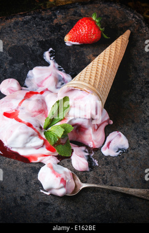 Wafer-Kegel mit Erdbeereis mit frischen Erdbeeren und Minze über schwarzen Tisch. Stockfoto