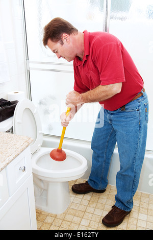 Der Mensch in seinem Badezimmer, eine Toilette mit einem Kolben freimachen. Stockfoto