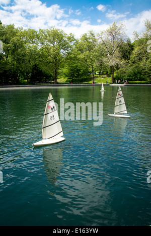 Modell Segelboote gleiten parallel über das Modell Boat Basin im Central Park in New York City. Stockfoto