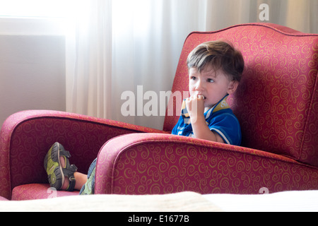 Junge auf einem Stuhl sitzend und vor dem Fernseher Stockfoto