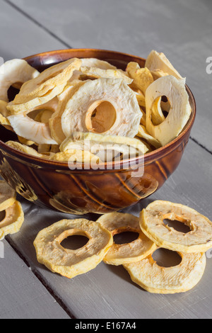 getrocknete Apfelringe in einer Schüssel auf Holztisch Stockfoto