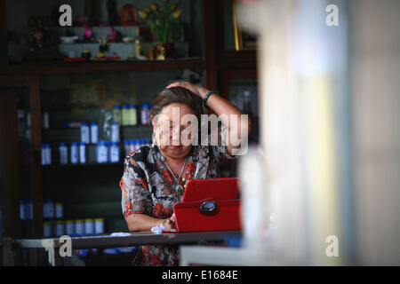 Chiang Mai, Thailand. 24. Mai 2014. Eine Frau, die hier durch screening-Ipad Innenstadt, Chiang Mai, Thailand.On 22 kann 2014 der thailändischen Armee unter Führung von General Prayuth Chan-Ocha übernahm die Kontrolle über das Königreich durch einen Militärputsch. Chiang Mai ist bekannt, das Kernland der Rothemden oder Thaksin-Anhänger werden. Bildnachweis: Rohan Radheya/ZUMAPRESS.com/Alamy Live-Nachrichten Stockfoto