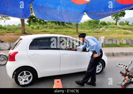 Islamabad, Pakistan. 24. Mai 2014. Ein pakistanischer Polizist prüft ein Auto bei einem Checkpoint aufgrund hoher Sicherheitswarnung in Islamabad, der Hauptstadt von Pakistan, am 24. Mai 2014. Ein Wachmann wurde getötet und einen anderen verletzt, wenn zwei separate Bombenanschläge der pakistanischen Hauptstadt Islamabad in den frühen Morgenstunden des Samstag morgens getroffen, sagten Beamte. Bildnachweis: Ahmad Kamal/Xinhua/Alamy Live-Nachrichten Stockfoto