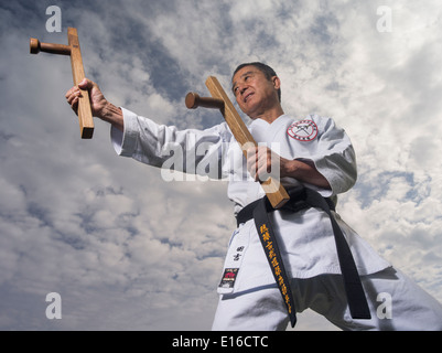 Karate & Kobudo Master Yukio Kuniyoshi. Kaicho des Ryukyu Kobudo Hozon Shinko Kai. Training auf Okinawa, Japan mit tonfa Stockfoto
