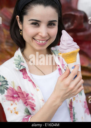 Frau (Modell freigegeben) Essen lila Kartoffel Eis Creme von Blue Seal auf Kokusai Street, Naha, Okinawa Stockfoto