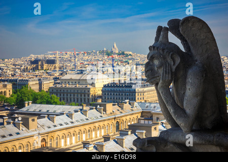 Die Stryge (am berühmtesten von den Chimeres) mit Blick auf die Basilika des Heiligen Herzens von Jesus an die Kathedrale Notre Dame in Paris Stockfoto