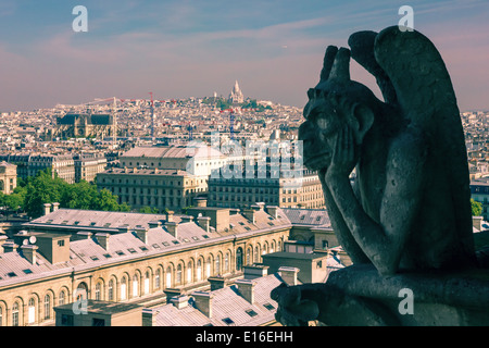 Die Stryge (am berühmtesten von den Chimeres) mit Blick auf die Basilika des Heiligen Herzens von Jesus an die Kathedrale Notre Dame in Paris Stockfoto