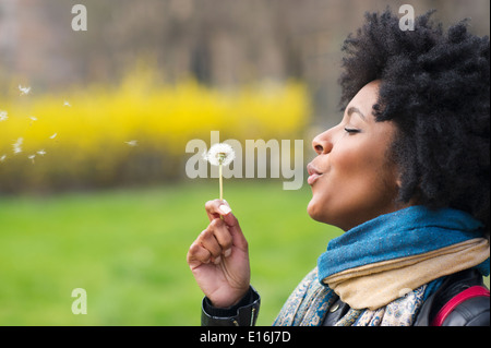 Porträt der Frau bläst Löwenzahn, Milano, Italien Stockfoto