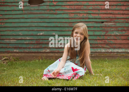 Mädchen (6-7) sitzen auf dem Rasen Stockfoto