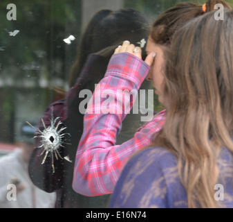 24. Mai 2014. Isla Vista, CA. UCSB Schüler versammeln sich am IV-Deli-Mart waren Einschusslöcher sind in die Glasfenster zu sehen waren, eine Person wurde getötet durch die vorbeifahren Schütze links sieben Tote Freitag Nacht, inklusive der Angreifer, und sieben andere verwundet, Behörden, sagte Saturday.The Schütze kam in zwei Feuergefechten mit Abgeordneten Freitagabend im Strandort von Isla Vista vor dem Absturz seiner schwarzen BMW in ein parkiertes Auto. Foto von täglichen NewsZUMAPRESS gen Blevins/LA (Kredit-Bild: © gen Blevins/ZUMAPRESS.com) Stockfoto