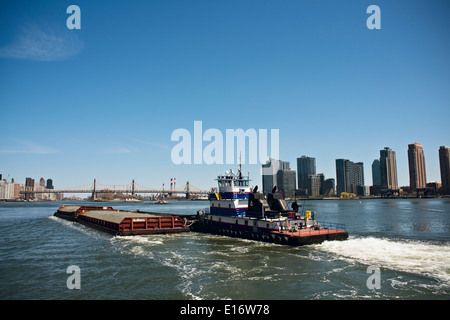 Schlepper drücken Lastkähne von Kies am New Yorker East River Stockfoto