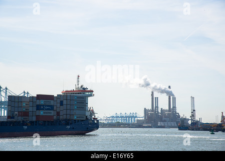 Containerschiff mit Fracht und Powerstation im Hintergrund Stockfoto