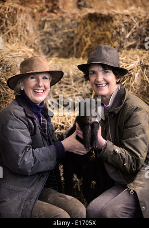 Zwei Bäuerinnen mit einem Neugeborenen Frühlingslamm aus ihrer Manx Loaghtan Herde von Schafen Wiltshire UK Stockfoto