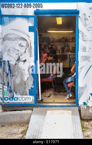 Friseursalon, Menschen im improvisierten Friseursalon und Friseur in Container, Imizamo Yethu Township (Mandela Park) Siedlung, Kapstadt, Südafrika Stockfoto