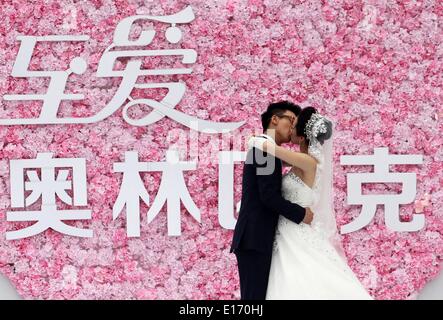 Weifang, China Shandong Provinz. 25. Mai 2014. Wu Jingyu (R), Chinas zweifache Champion Olympic Taekwondo 49 kg Kategorie, ist von der Bräutigam Hou Kun während ihrer Hochzeit in Weifang, Ost-China Shandong Provinz, 25. Mai 2014 geküsst. © Zhang Chi/Xinhua/Alamy Live-Nachrichten Stockfoto