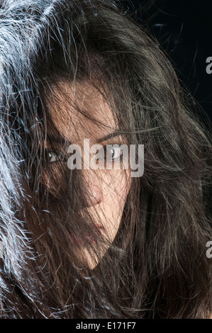 Schöne junge Frau Haar bedeckte Gesicht Stockfoto