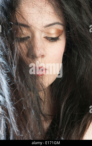 Schöne junge Frau, die in Gedanken versunken Stockfoto