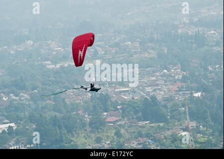 Bogor, Provinz West-Java in Indonesien. 25. Mai 2014. Ein Gleitschirm fliegt während Fun Fly Paragliding Festival in Puncak, Bogor, Provinz West-Java in Indonesien, 25. Mai 2014. Mehr als hundert Teilnehmer in verschiedenen Arten von Kostümen teilnehmen in diesem Festival. Bildnachweis: Veri Sanovri/Xinhua/Alamy Live-Nachrichten Stockfoto