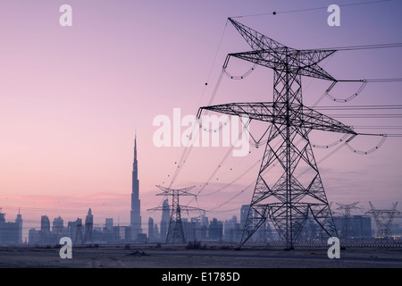 Stromleitungen und Pylonen und Skyline in der Abenddämmerung in Dubai Vereinigte Arabische Emirate Stockfoto