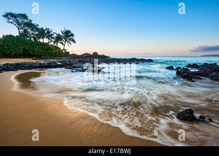 Sonnenaufgang über dem schönsten und einsamsten Secret Beach auf Maui, Hawaii. Stockfoto