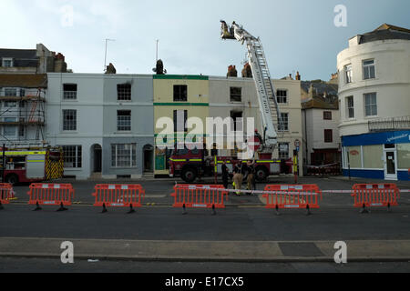 Hastings Marine Parade, Feuerwehrleute untersuchen ausgebrannte Hülle der Terrasse Häuser entkernt durch einen Brand am 25. Mai 2014 Stockfoto