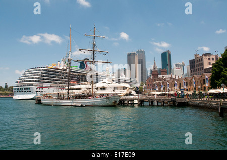 Schiffe, die unter anderem das Kreuzfahrtschiff Carnival Spirit Liegeplatz im Hafen von Sydney vor dem Hintergrund von The Rocks und Central Busines Stockfoto