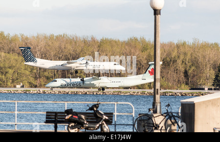 Porter Flugzeug Landung überfliegt ein Air Canada Flugzeug bereit zum Abheben an Billy Bishop Airport auf den Toronto Islands. Stockfoto