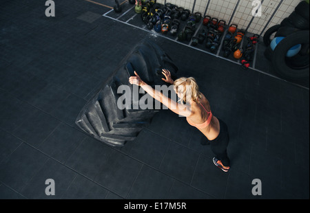 CrossFit Frau im Fitness-Studio trainieren. Muskulöse Frauen spiegeln sehr großer Gummireifen Stockfoto
