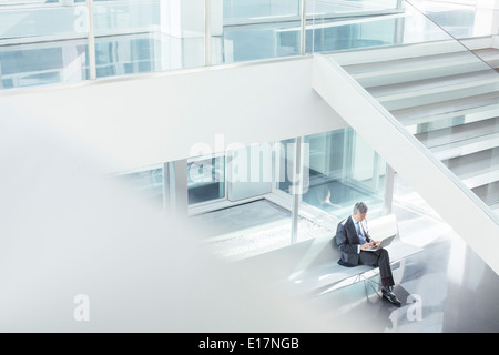 Geschäftsmann mit Laptop im modernen Büro Stockfoto