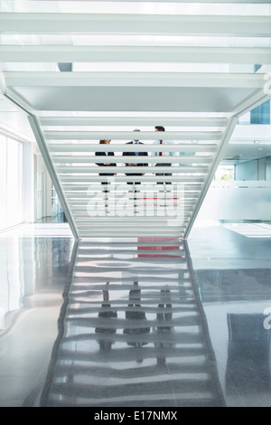 Geschäftsleute, die moderne Treppe im Büro aufsteigend Stockfoto