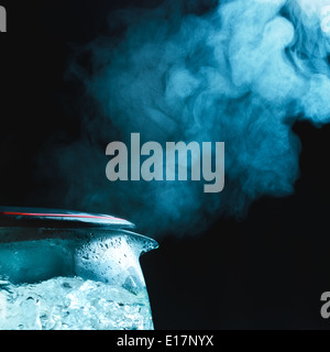 Teekanne mit kochendem Wasser, dunkler Hintergrund Stockfoto