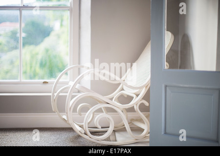 Antiker Schaukelstuhl in Ecke Stockfoto