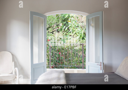 Fenstertüren öffnen sich zum Balkon in Luxus Schlafzimmer Stockfoto