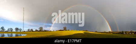 Ein atemberaubende doppelter Regenbogen wird in der niedrigen Abend Sonne sichtbar, wenn ein Sturm in der Ferne in der Nähe von Wychbold schwindet Stockfoto