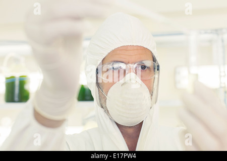 Wissenschaftler in sauberen Anzug mit Pipette und Reagenzglas Stockfoto