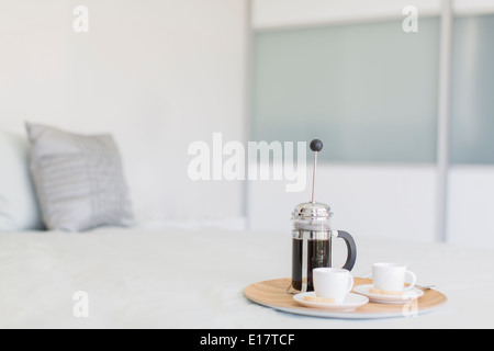 Französische Presse Kaffee und Tassen auf Tablett im Schlafzimmer Stockfoto