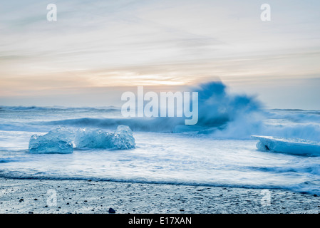 Eisberge und Wellen an der Küste am Breidamerkurfjara Strand in der Nähe von Vatnajökull-Eiskappe, Island Stockfoto