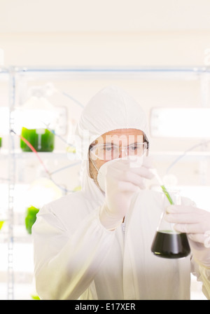 Wissenschaftler in sauberen Anzug mit Becher im Labor Stockfoto