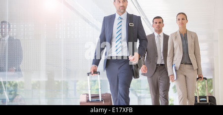 Geschäftsleute, die Koffer im Flur ziehen Stockfoto