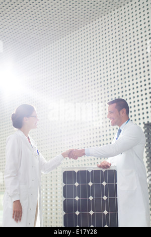 Wissenschaftler-Handshake bei Solar-Panel im Labor Stockfoto