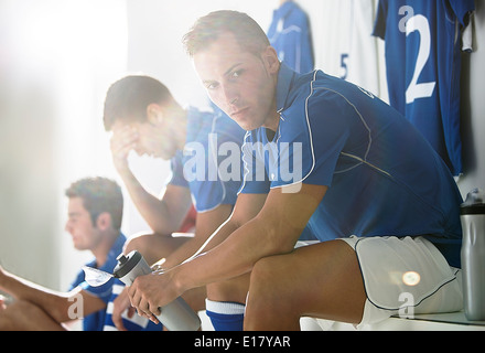 Fußball-Spieler sitzen in Umkleidekabine Stockfoto
