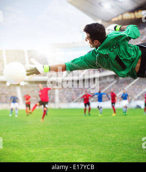 Torwart für Ball in der Luft am Fußballplatz zu erreichen Stockfoto